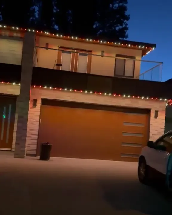 The same home at night with the roofline lights on