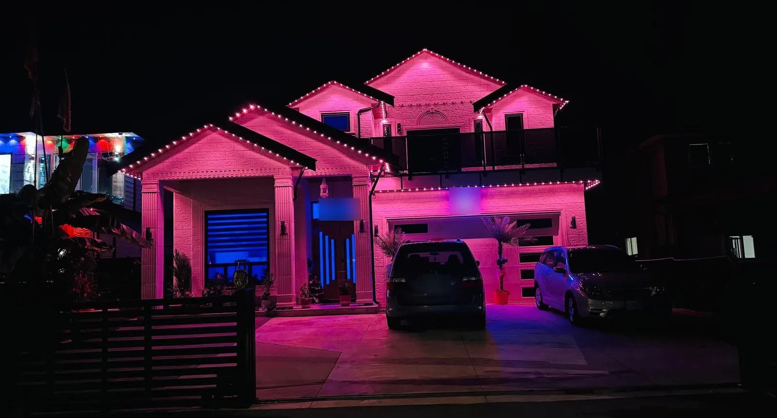 Stone-front home with roofline lights in pink
